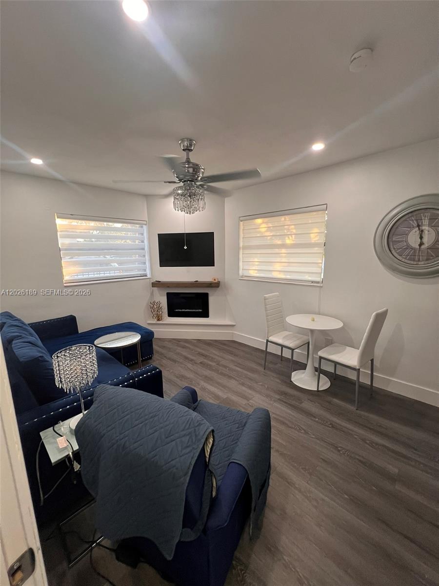 A living room features a blue sofa, a small dining set, and a corner fireplace — 3411 SW 121st Ave, Miami FL 33175, MIAMI, FL
