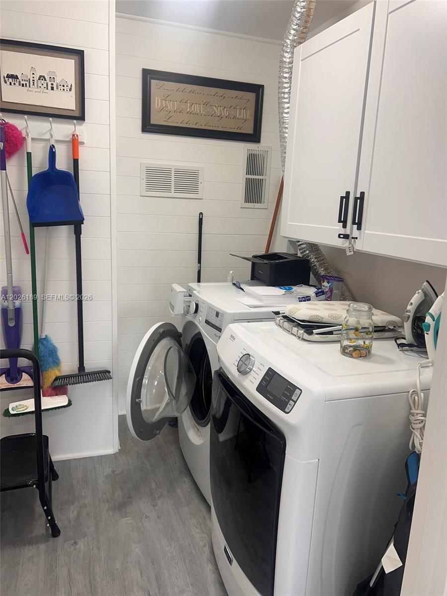 A laundry room features white cabinets, a washer and dryer, and wall-mounted cleaning supplies — 3411 SW 121st Ave, Miami FL 33175, MIAMI, FL