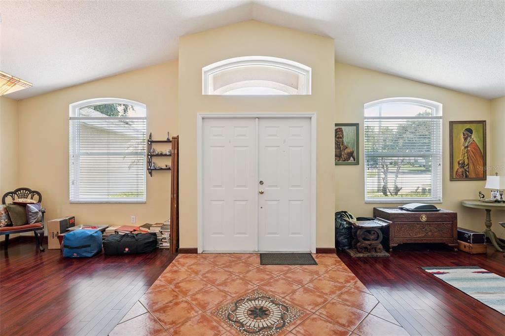 An entryway features a double front door, arched windows, tile flooring, and dark wood floors — 1796 FLORENCE VISTA BOULEVARD, ORLANDO, FL