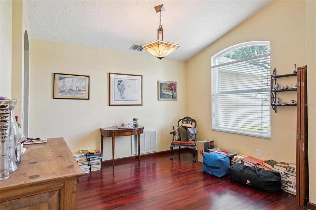 A dining room with hardwood floors, a vaulted ceiling, a chandelier, and a large window — 1796 FLORENCE VISTA BOULEVARD, ORLANDO, FL