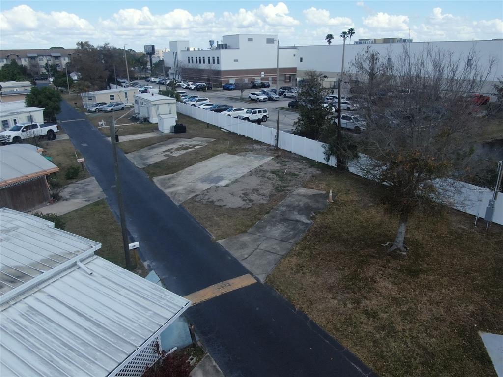 An aerial view shows a vacant residential lot with concrete pads next to a paved road — 6720 PARK BOULEVARD N UNIT 20, PINELLAS PARK, FL