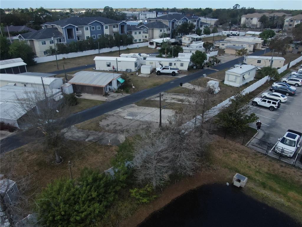 An aerial view shows a mobile home park with a vacant concrete lot in the foreground — 6720 PARK BOULEVARD N UNIT 20, PINELLAS PARK, FL
