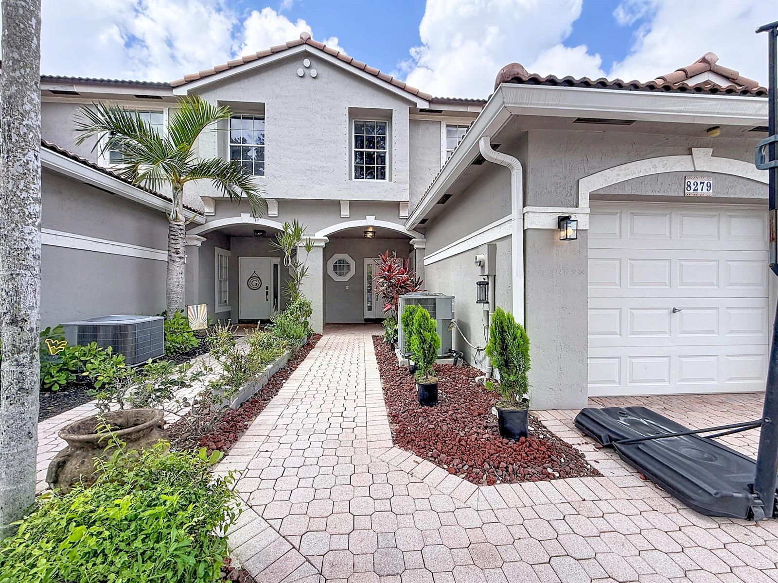 A paved walkway leads to the front entrance of a two-story house with a garage — 8279 Via Leonessa Drive, Boca Raton FL 33433, BOCA RATON, FL