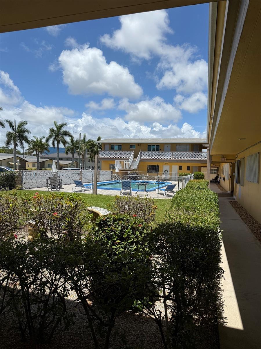 A view of a swimming pool and courtyard area from a covered outdoor walkway — 3525 Polk St # 7, Hollywood FL 33021, HOLLYWOOD, FL