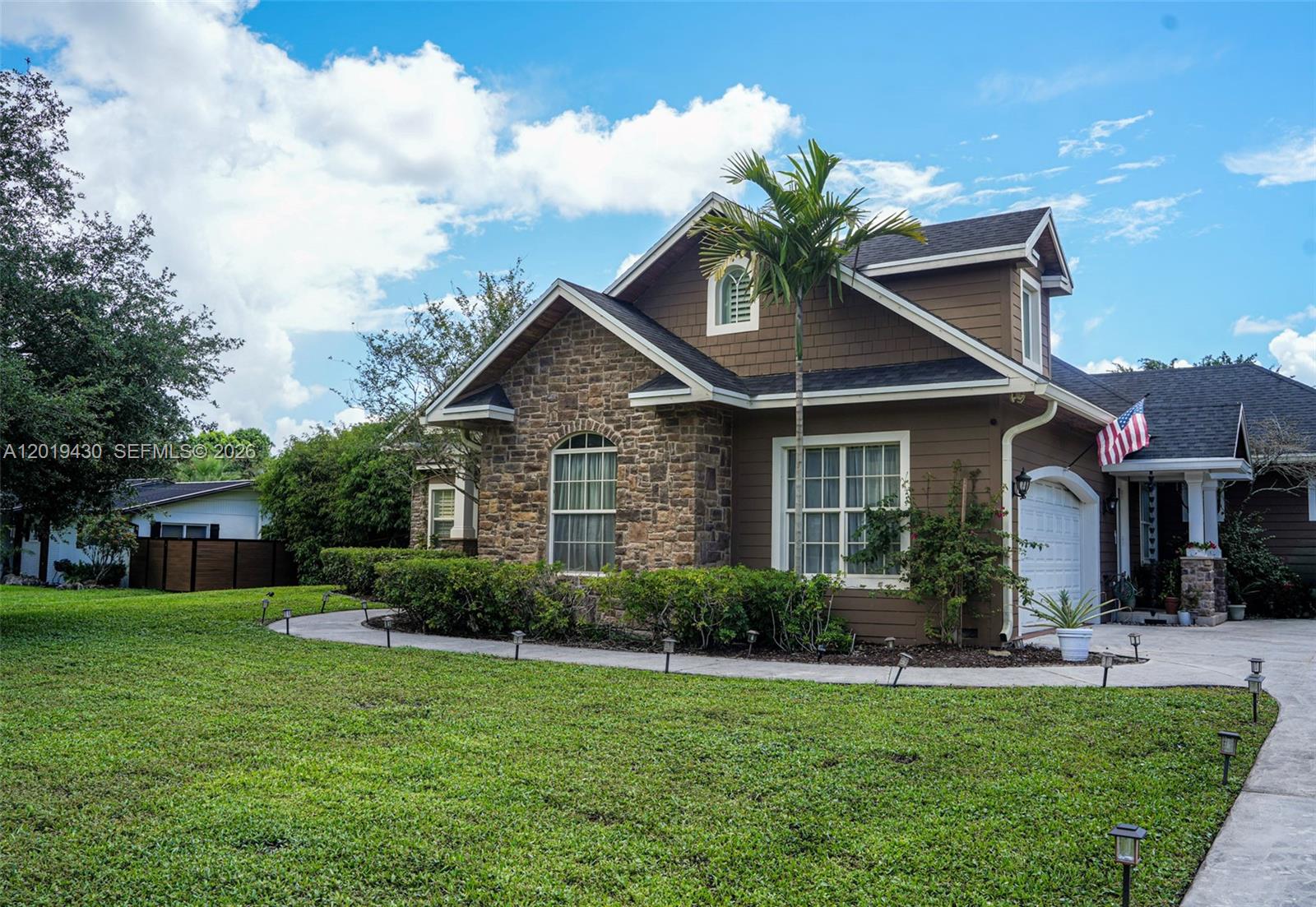 A two-story house with brown siding, stone accents, and a palm tree in the front yard — 2640 SW 137th Ter, Davie FL 33330, DAVIE, FL