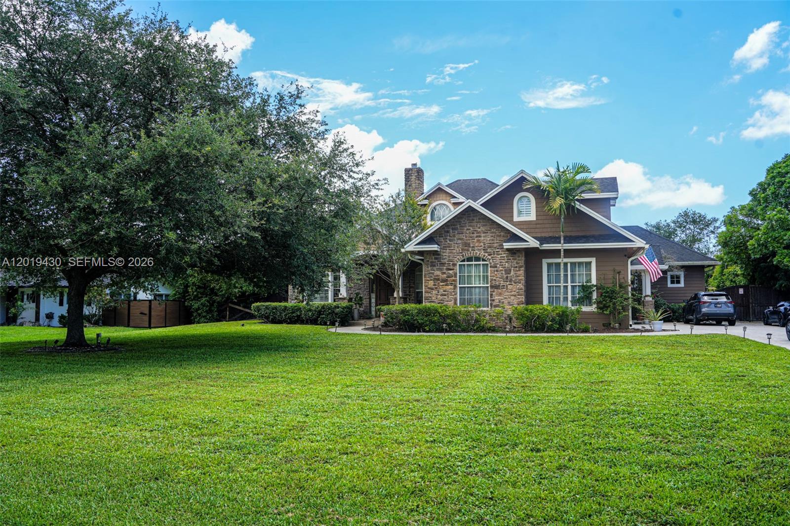 A two-story house with a stone facade, brown siding, and a large front lawn — 2640 SW 137th Ter, Davie FL 33330, DAVIE, FL