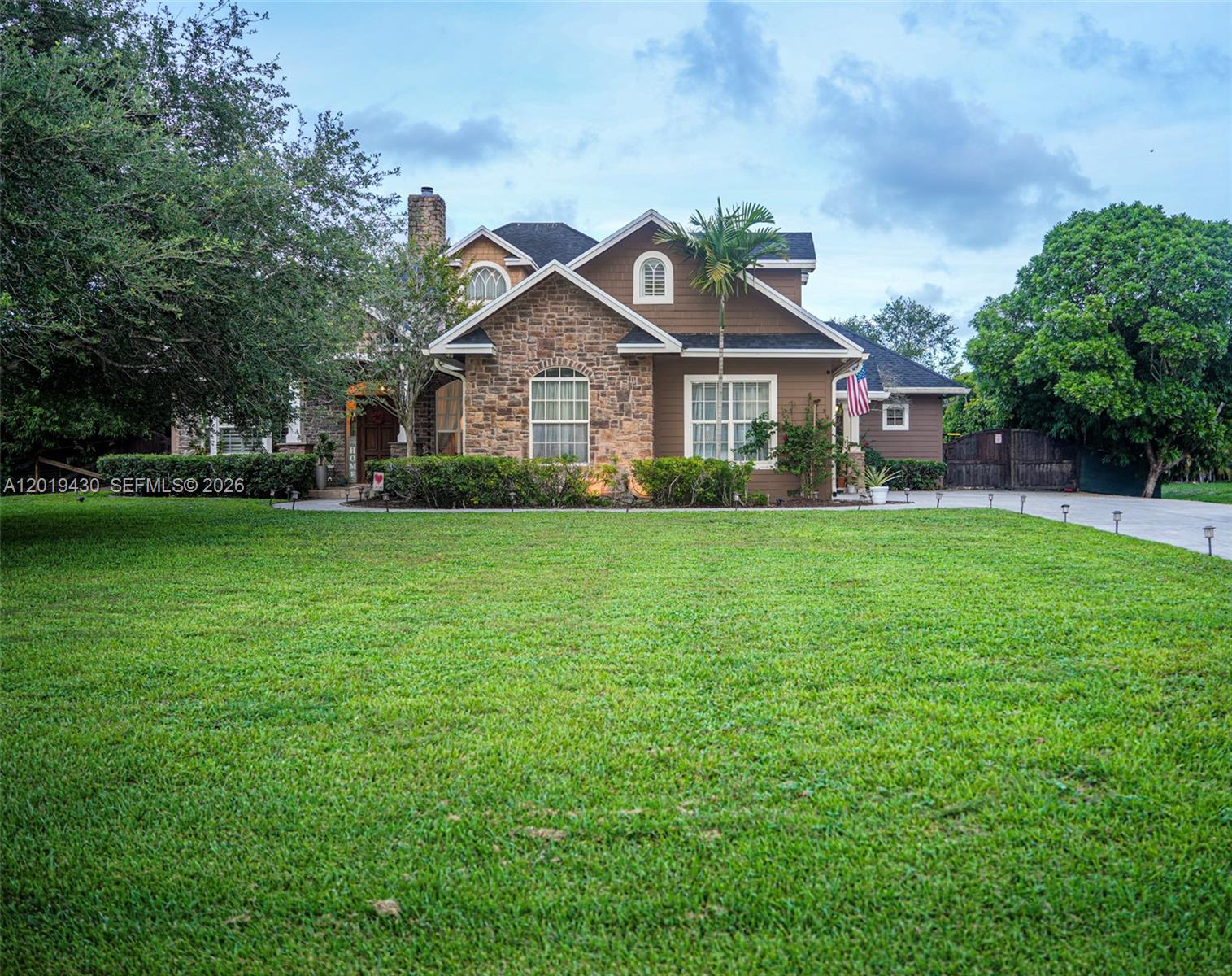A two-story house with a stone facade, brown siding, and a large front lawn — 2640 SW 137th Ter, Davie FL 33330, DAVIE, FL