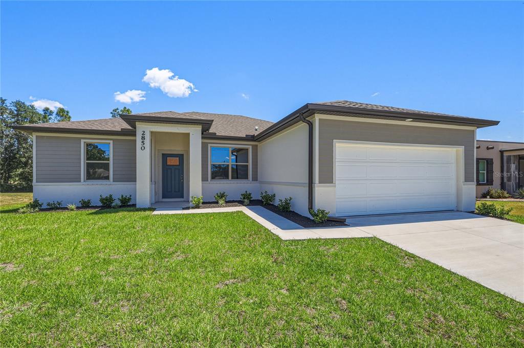 A single-story house with a white garage, gray siding, and a covered front entryway — 2850 ESCAMBIA CIRCLE, NORTH PORT, FL