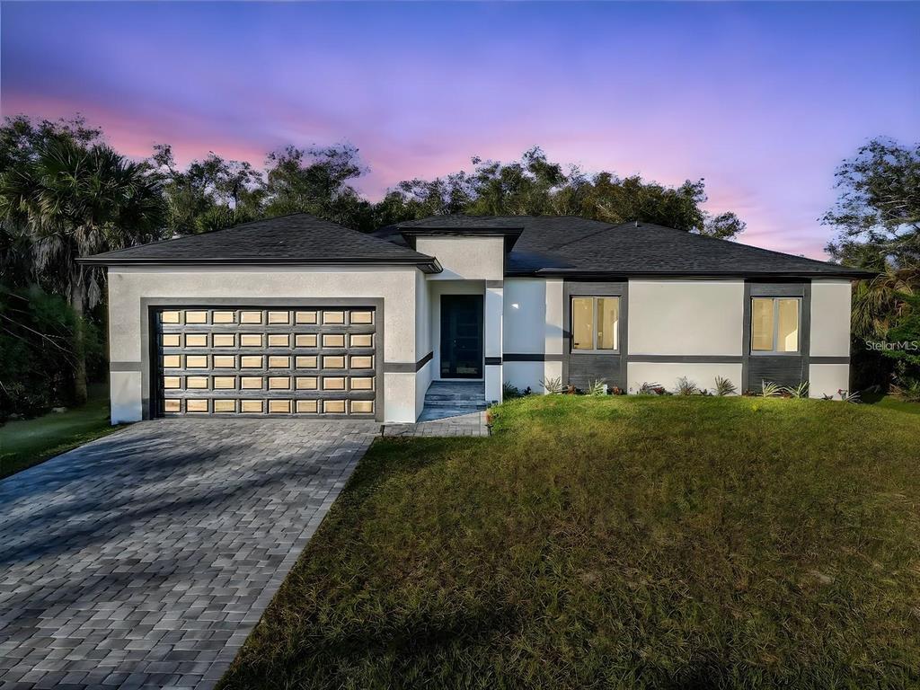 A single-story house with a paved driveway, a two-car garage, and a dark front door — 493 SYCAMORE, PORT CHARLOTTE, FL