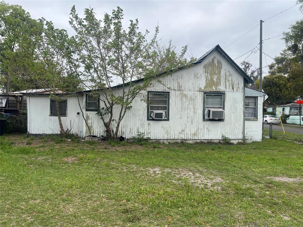 The exterior of a weathered, single-story house with white vertical siding and several windows — 11760 N WILLIAMS STREET, DUNNELLON, FL