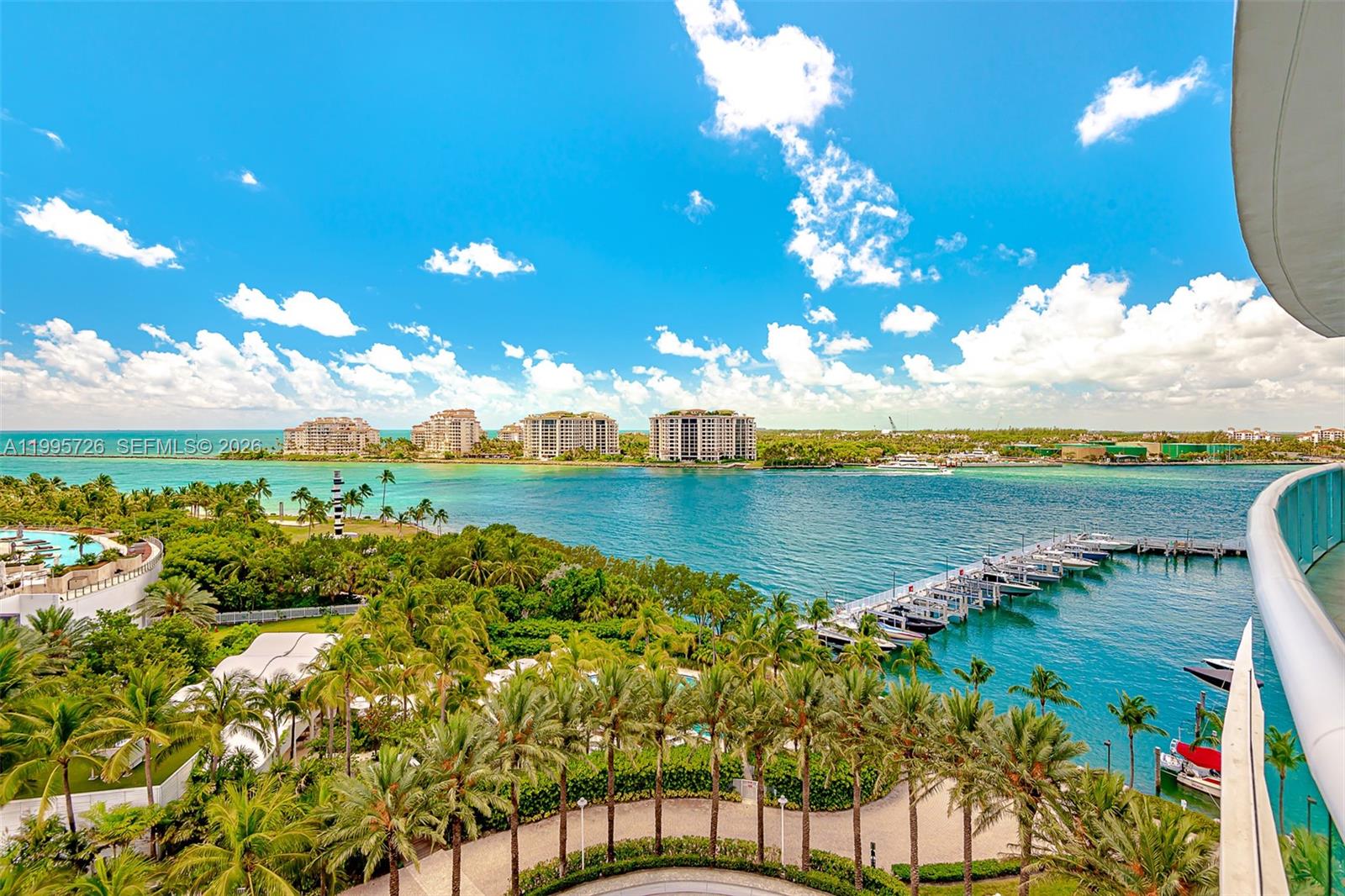 An elevated view shows a marina, palm trees, and high-rise buildings along a blue waterway — 1000 S Pointe Drive # 905, Miami Beach FL 33139, MIAMI BEACH, FL