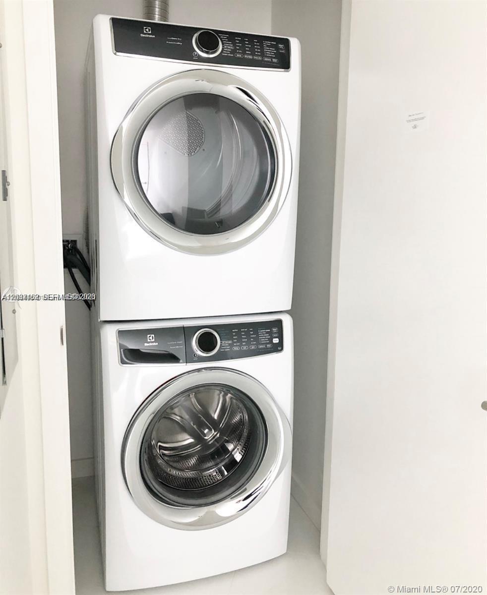 A stacked Electrolux washer and dryer unit is installed inside a small white laundry closet — MIAMI, FL