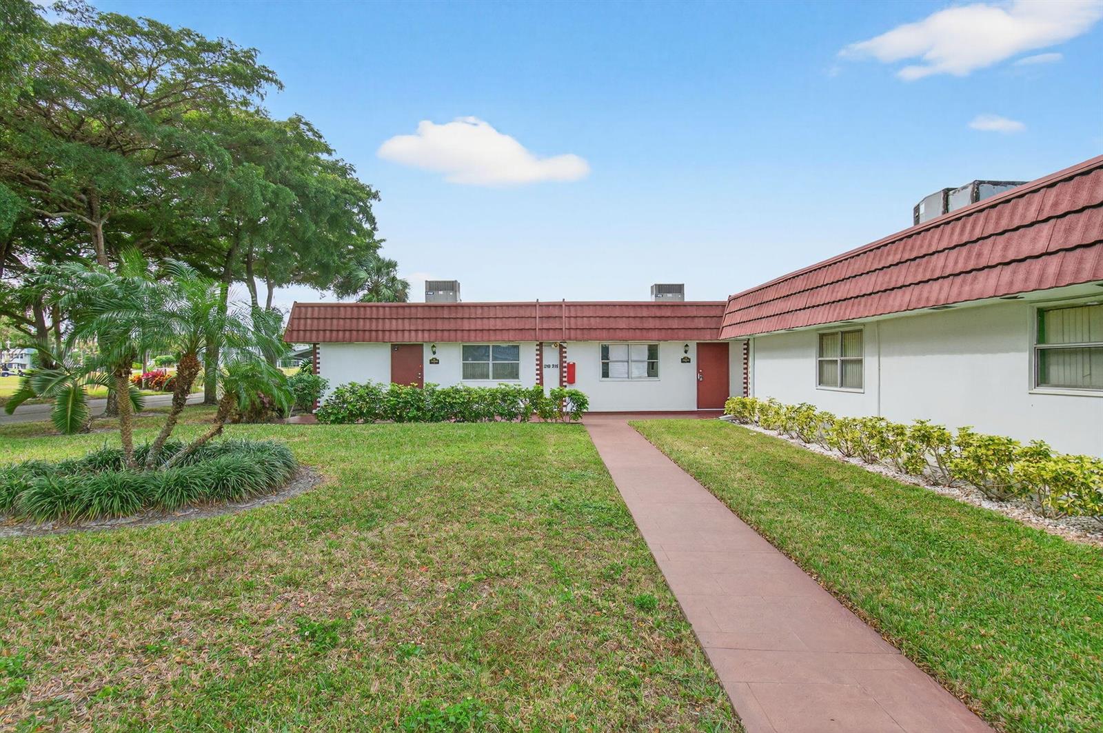 A single-story building with a red tiled roof, white walls, and a paved walkway — 213 Waterford I, Delray Beach FL 33446, DELRAY BEACH, FL