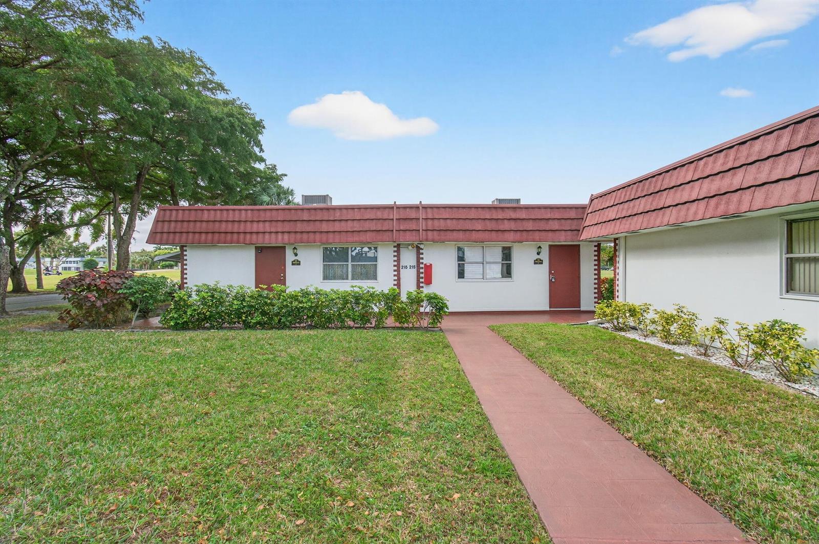 A single-story building with a red tiled roof, white walls, and a concrete walkway — 213 Waterford I, Delray Beach FL 33446, DELRAY BEACH, FL