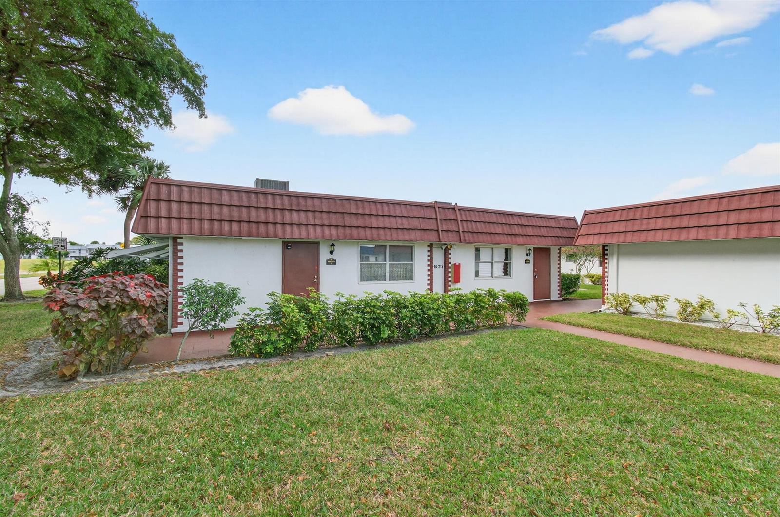 A single-story residential building with a brown mansard roof and white stucco exterior walls — 213 Waterford I, Delray Beach FL 33446, DELRAY BEACH, FL