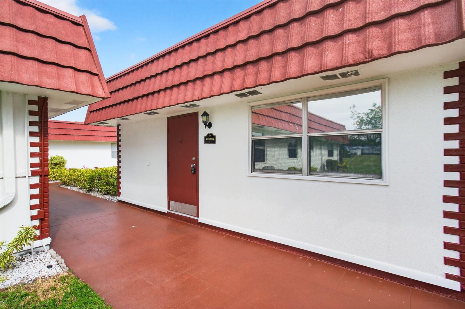 Exterior view of a white building with a red tiled roof and red door — 213 Waterford I, Delray Beach FL 33446, DELRAY BEACH, FL