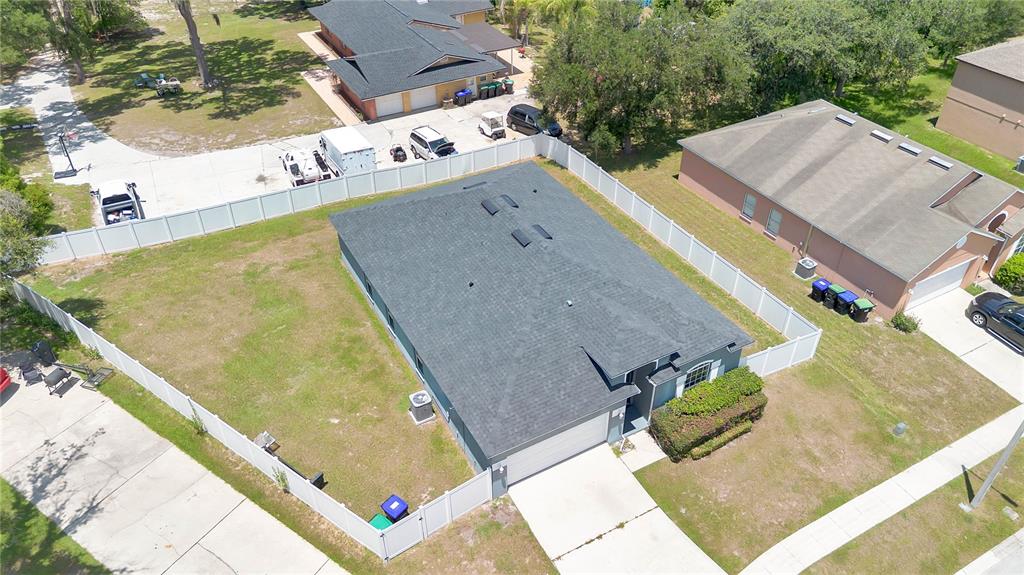 An aerial view shows a single-story house with a dark roof inside a fenced yard — 7933 REX HILL TRAIL, ORLANDO, FL