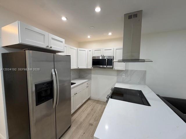 A modern kitchen features white cabinets, stainless steel appliances, and a white quartz countertop island — 500 Layne Blvd # 19, Hallandale Beach FL 33009, HALLANDALE BEACH, FL