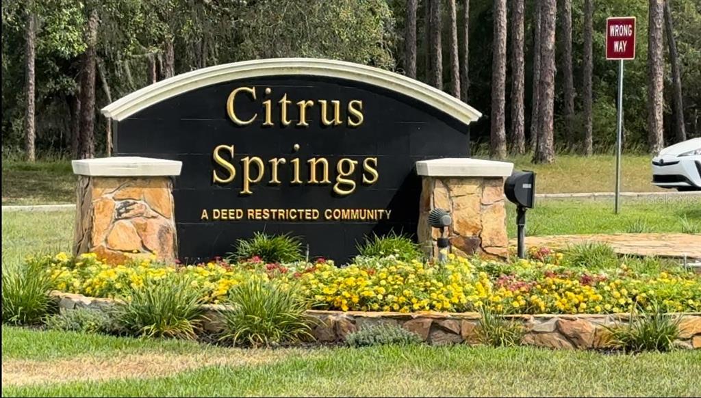A stone and black sign for the Citrus Springs community sits behind a flower bed — 8332 N FARRINGTON DRIVE, CITRUS SPRINGS, FL