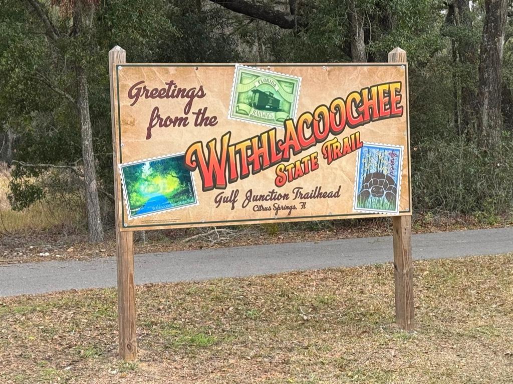 A sign for the Withlacoochee State Trail Gulf Junction Trailhead stands in a wooded area — 8332 N FARRINGTON DRIVE, CITRUS SPRINGS, FL