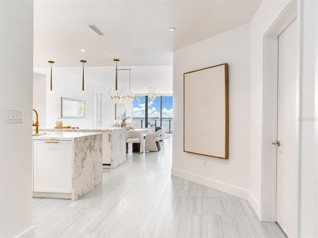 A bright, modern kitchen and dining area with marble islands and floor-to-ceiling windows — 3101 W BAYSHORE BOULEVARD UNIT 402, TAMPA, FL