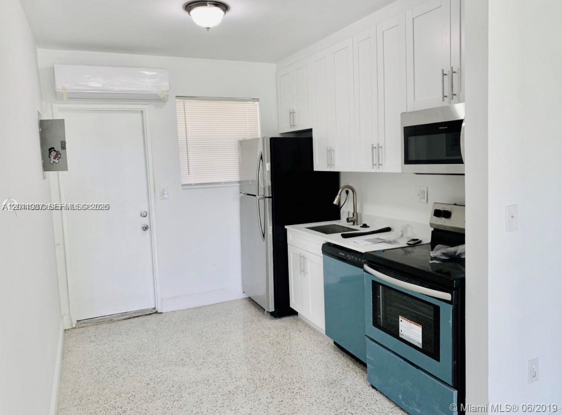A small kitchen features white cabinets, stainless steel appliances, and light-colored terrazzo flooring — 7731 NW 2nd Ave # 6, Miami FL 33150, MIAMI, FL