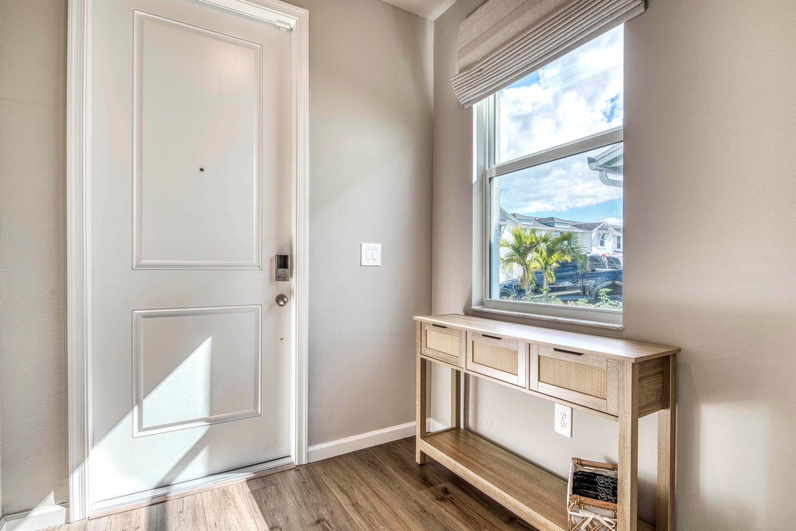An entryway features a white door, a wooden console table, and a window with blinds — 5735 SE Edgewater Circle, Stuart FL 34997, STUART, FL