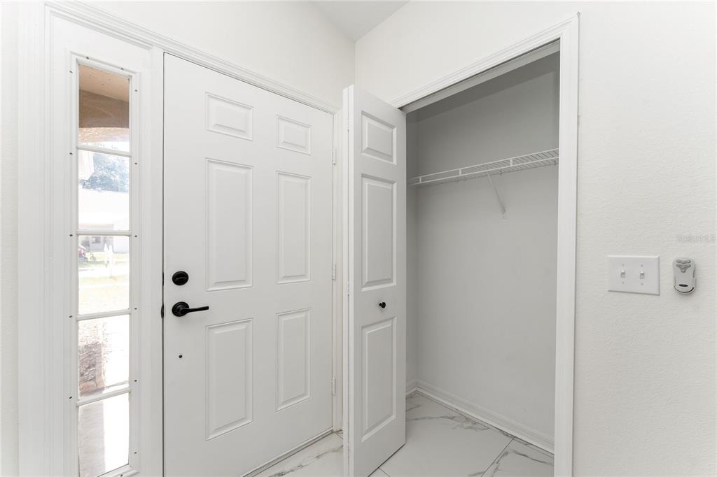 An entryway features a white front door, a coat closet, and light-colored tile flooring — 519 SUMMER SAILS DRIVE, VALRICO, FL