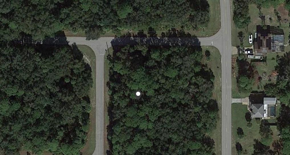 An aerial view shows a wooded, undeveloped corner lot situated between two paved roads — 3052 BUNKER HILL STREET, PORT CHARLOTTE, FL