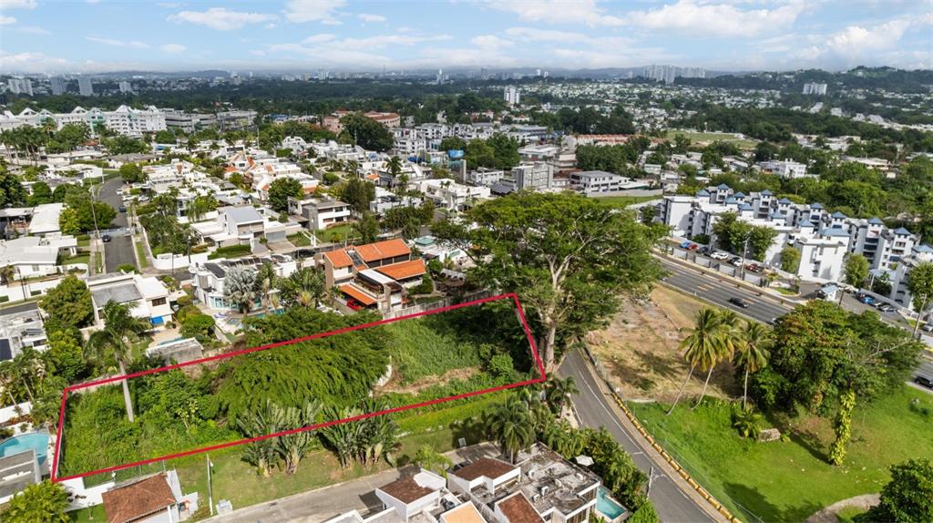 An aerial view shows a vacant, rectangular lot outlined in red within a residential neighborhood — STATE ROAD #2 MARGINAL ROAD, GUAYNABO, PR
