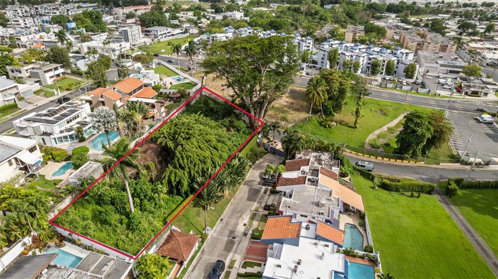 An aerial view shows a rectangular, tree-covered vacant lot outlined in red within a neighborhood — STATE ROAD #2 MARGINAL ROAD, GUAYNABO, PR