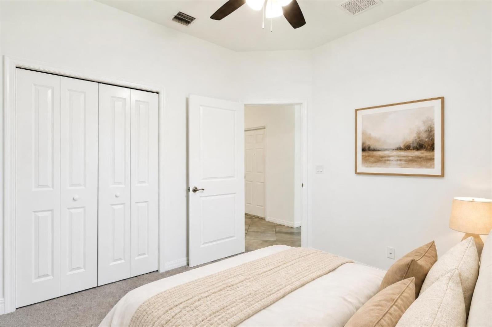 A bedroom features white walls, a ceiling fan, a closet, and a bed with pillows — 2055 46th Avenue, Vero Beach FL 32966, VERO BEACH, FL