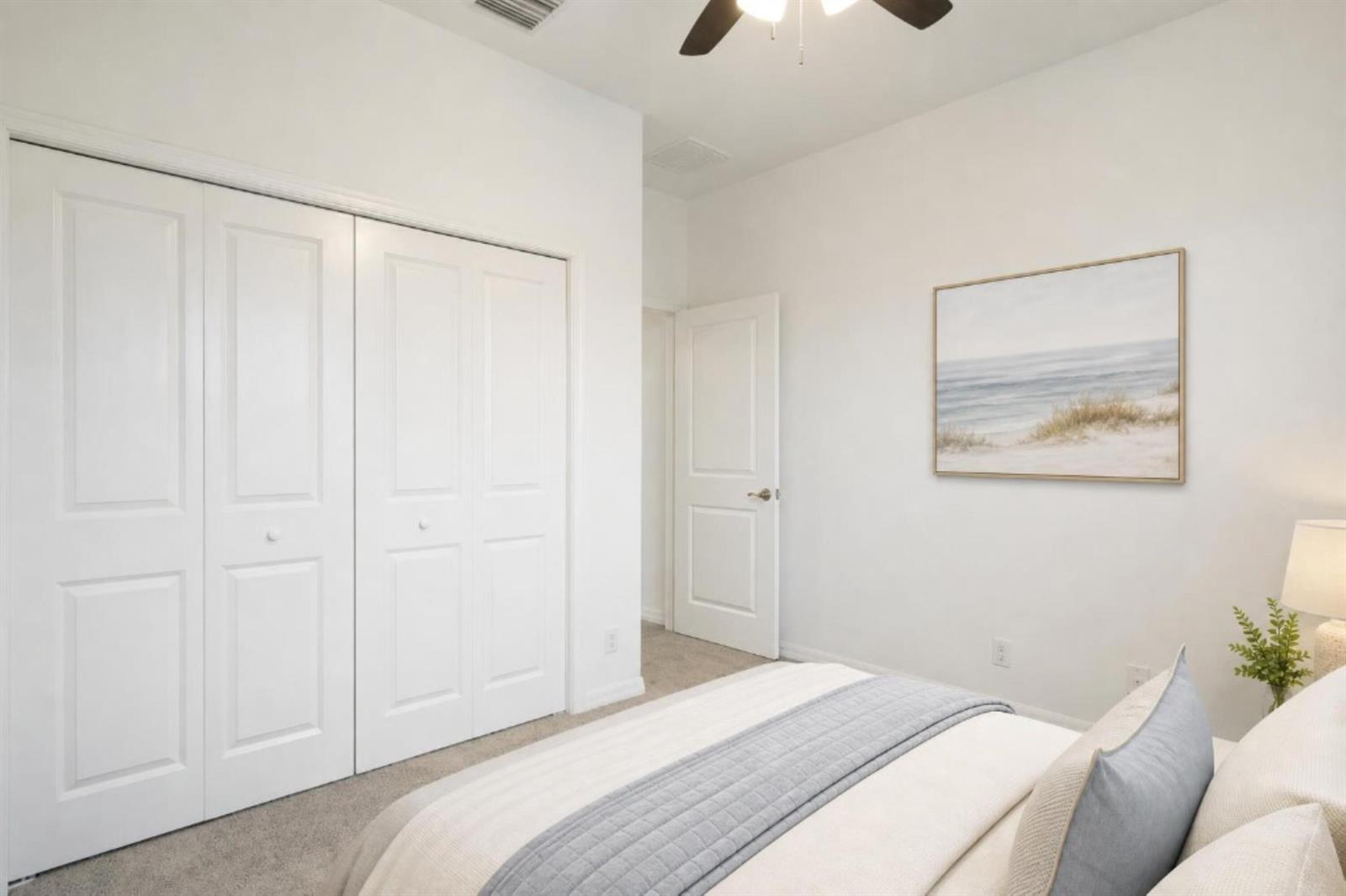 A bedroom features white walls, carpeted flooring, a closet with double doors, and a bed — 2055 46th Avenue, Vero Beach FL 32966, VERO BEACH, FL