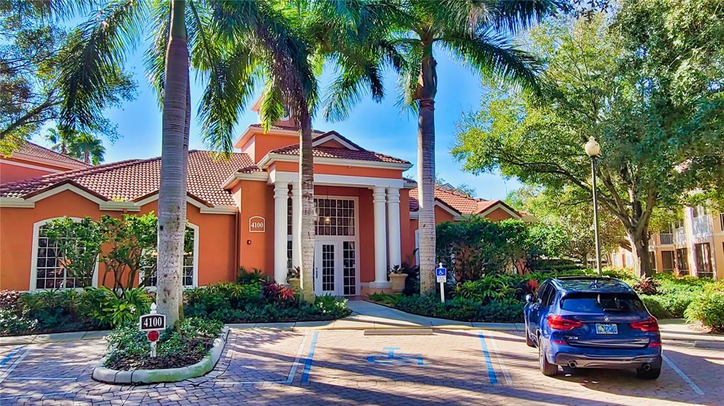 A blue SUV is parked in front of an orange building with palm trees — 4134 CENTRAL SARASOTA PARKWAY UNIT 1735, SARASOTA, FL
