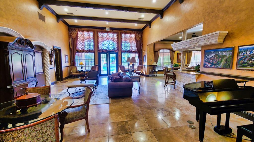 A spacious, high-ceilinged lobby features tile floors, a grand piano, and multiple seating areas — 4134 CENTRAL SARASOTA PARKWAY UNIT 1735, SARASOTA, FL
