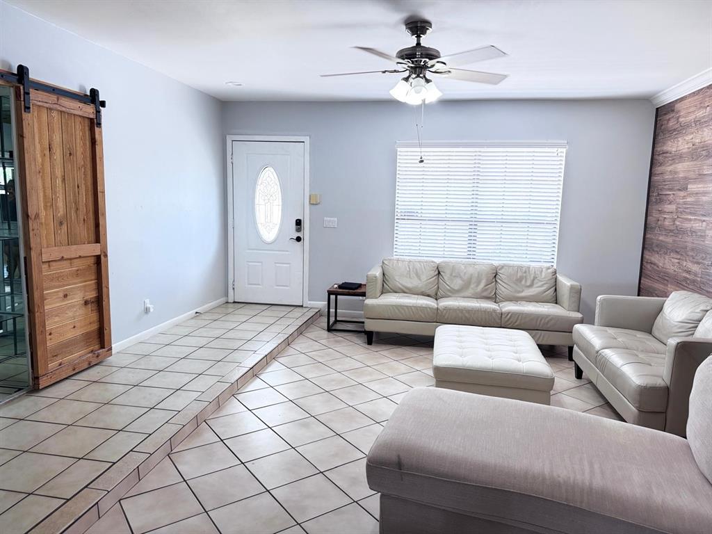 A living room features a tiled floor, a white front door, and light-colored leather furniture — 11088 NW 23RD COURT, SUNRISE, FL