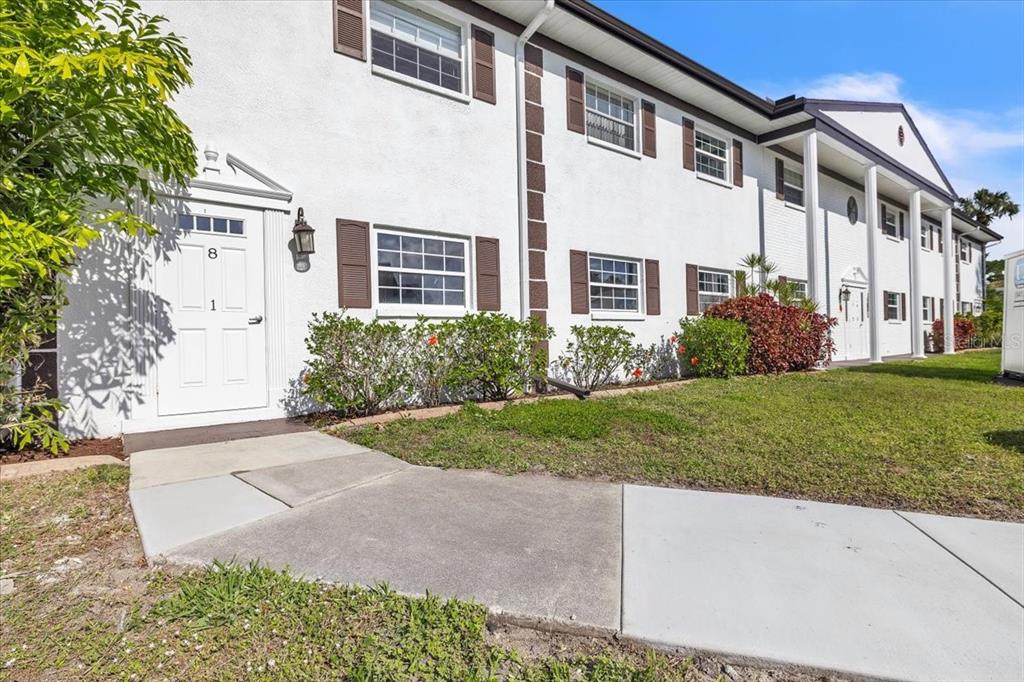 A two-story white apartment building with brown shutters and a concrete walkway — 7043 NEW POST DRIVE UNIT 1, NORTH FORT MYERS, FL