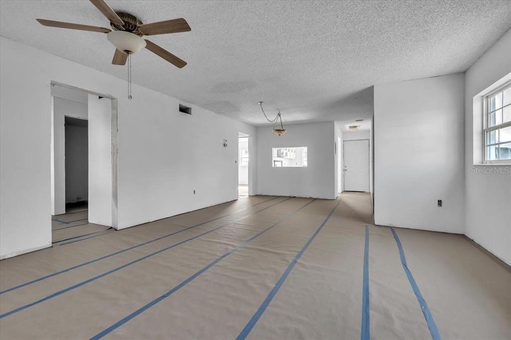 An empty room with white walls, a ceiling fan, and paper-covered floors — 7043 NEW POST DRIVE UNIT 1, NORTH FORT MYERS, FL