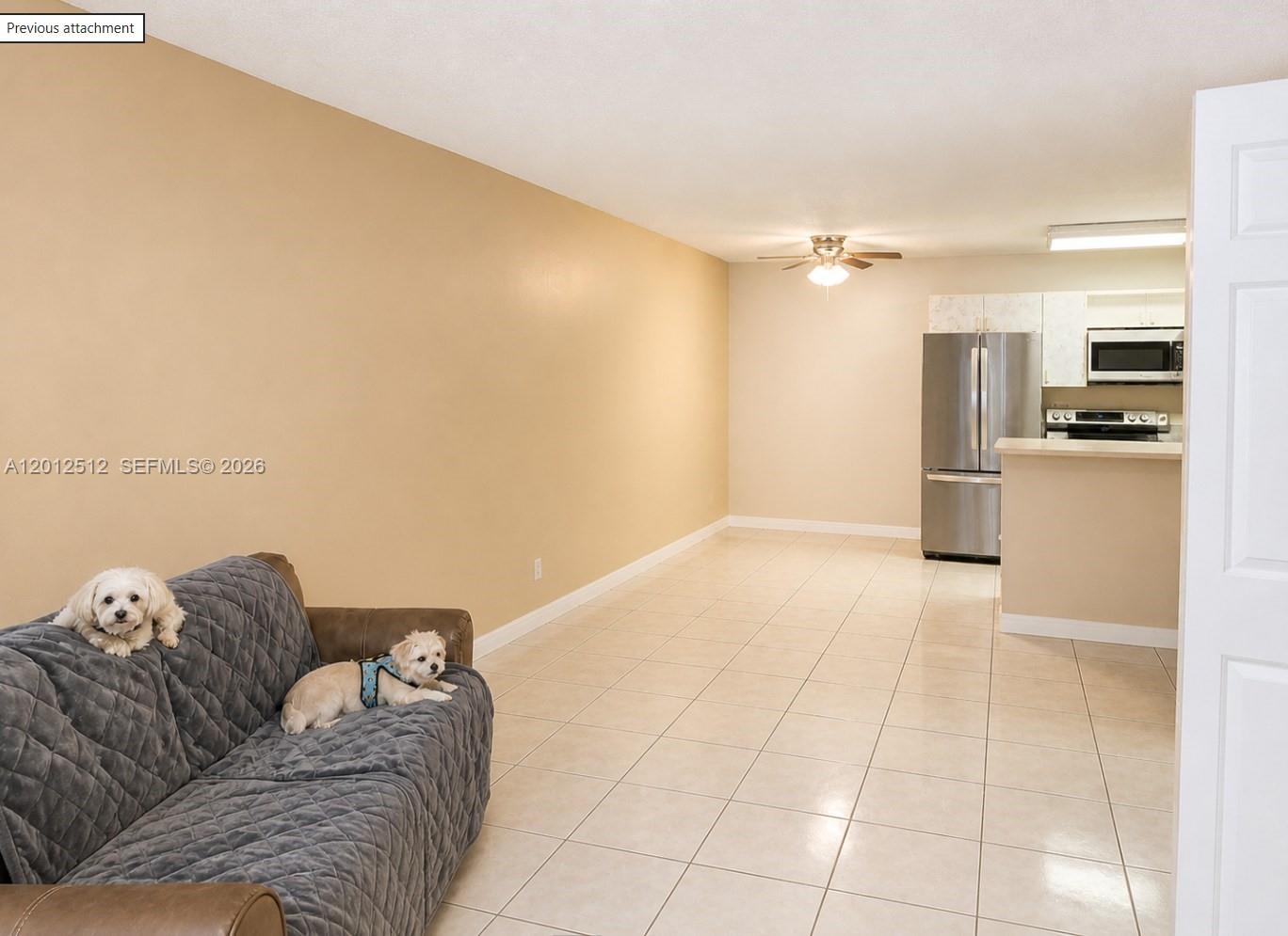 A living room with tile floors and a sofa leads to an open-concept kitchen — 15619 SW 73rd Cir Ter # 9, Miami FL 33193, MIAMI, FL