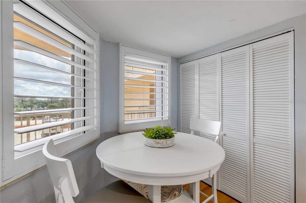 A small dining area features a white round table, two chairs, and white louvered shutters — 257 MINORCA BEACH WAY UNIT 103, NEW SMYRNA BEACH, FL