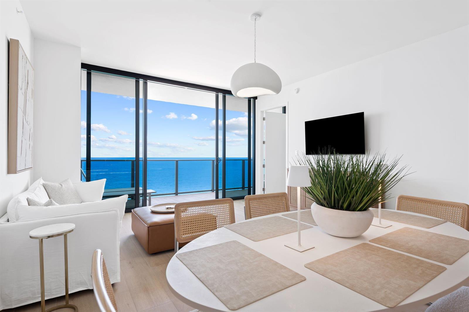 A bright dining and living area features a balcony with an ocean view — 900 N Ocean Boulevard # 1404, Pompano Beach FL 33062, POMPANO BEACH, FL
