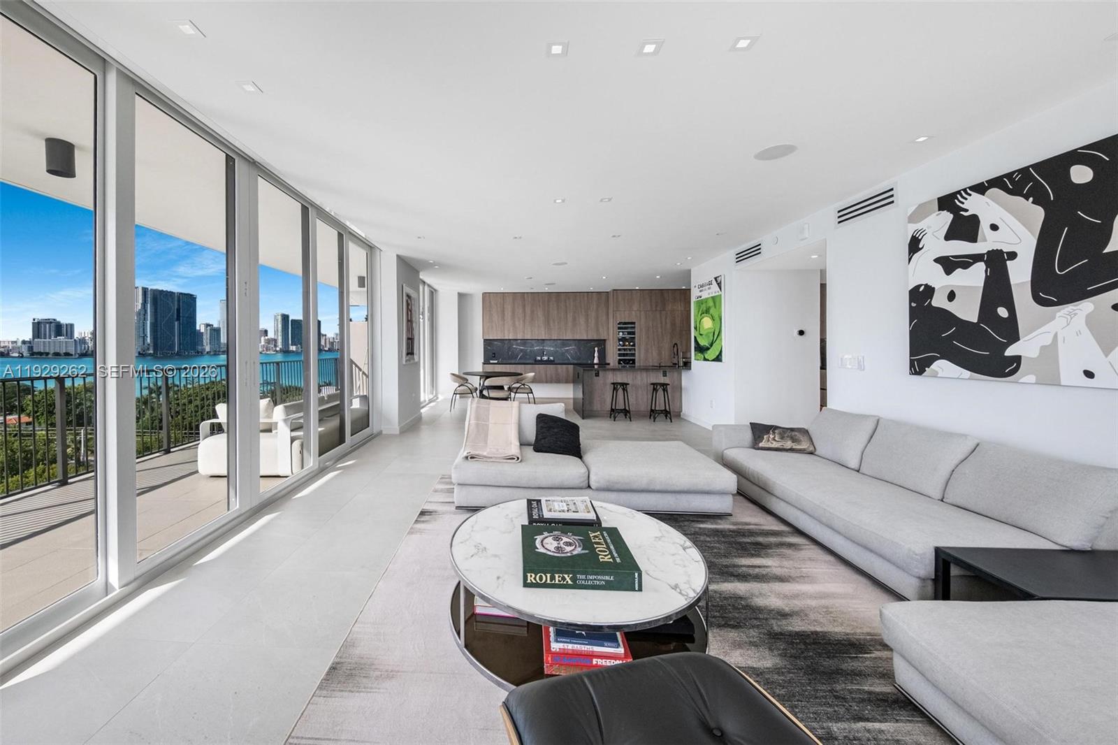 A modern living room with a sectional sofa, marble coffee table, and floor-to-ceiling balcony windows — 1000 Venetian Way # 1004, Miami FL 33139, MIAMI, FL