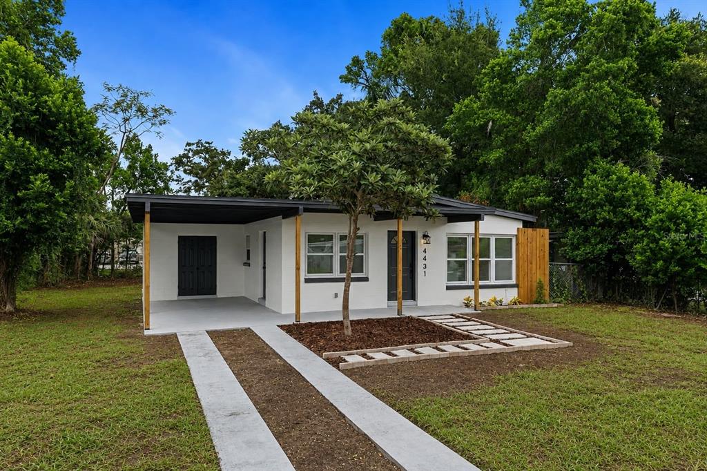 A single-story white house with a carport, a front tree, and a concrete walkway — 4431 SOUTHMORE DRIVE, ORLANDO, FL