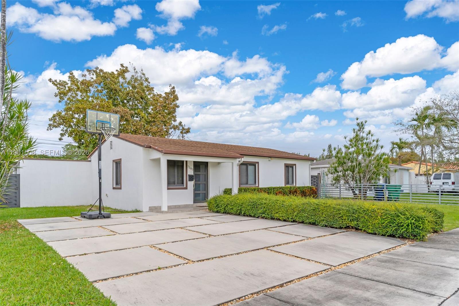 A single-story white house with a concrete slab driveway and a basketball hoop — 7585 SW 28th St, Miami FL 33155, MIAMI, FL