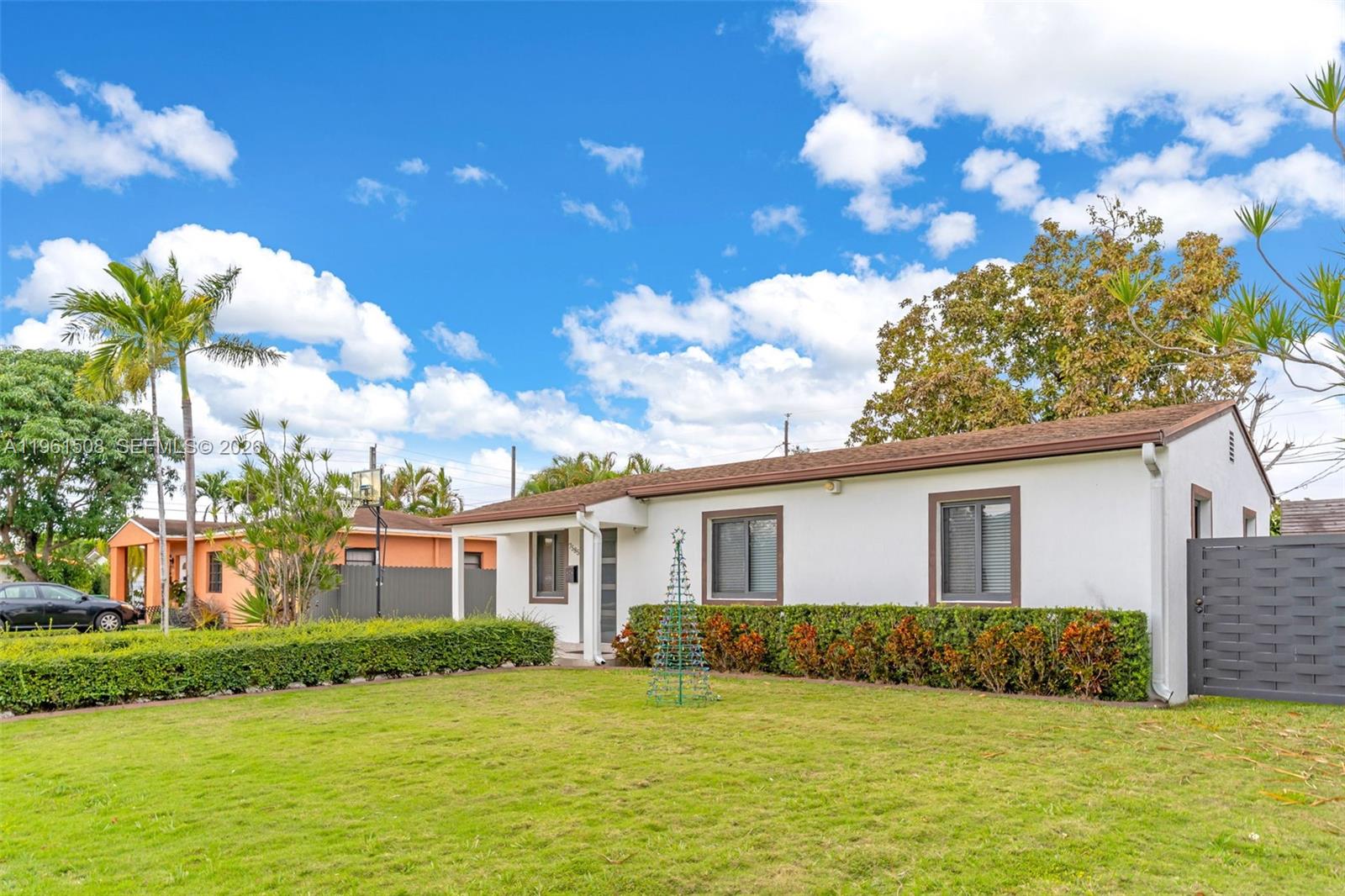A white single-story house with brown trim features a green lawn and a palm tree — 7585 SW 28th St, Miami FL 33155, MIAMI, FL