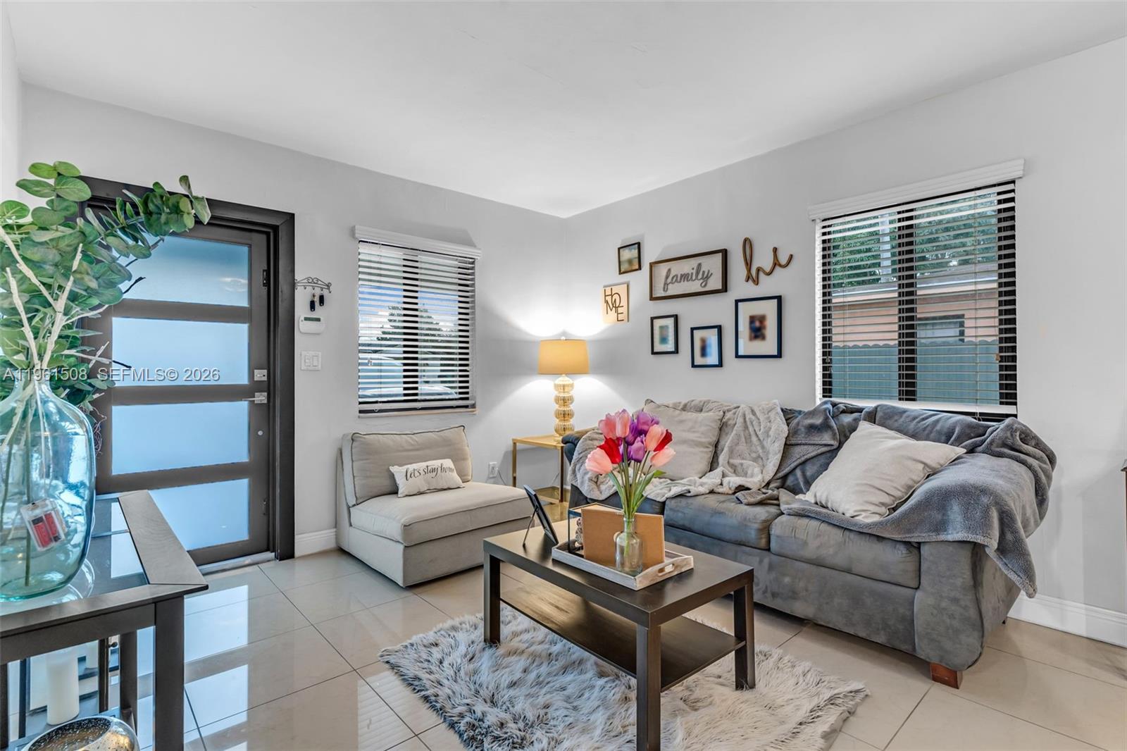 A living room features a grey sofa, a matching armchair, and a dark coffee table — 7585 SW 28th St, Miami FL 33155, MIAMI, FL