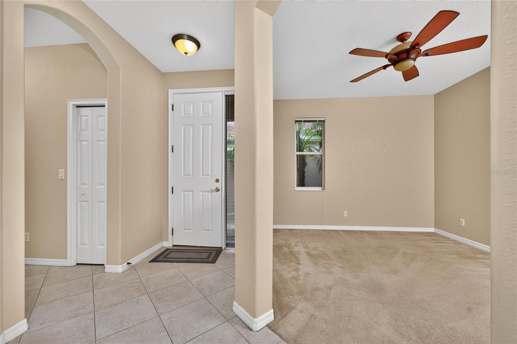 An entryway with tiled floors leads to a carpeted room featuring a ceiling fan — 246 MESTRE PLACE, NORTH VENICE, FL