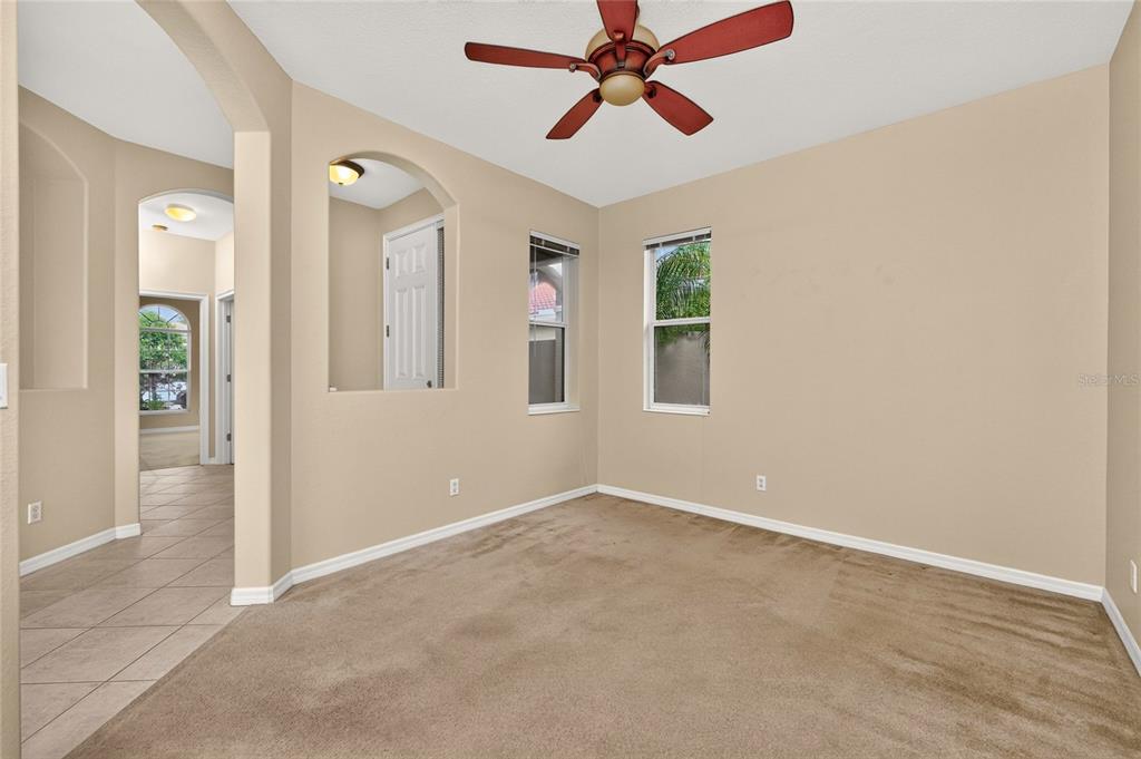 An empty room with beige carpet, tan walls, a ceiling fan, and two windows — 246 MESTRE PLACE, NORTH VENICE, FL