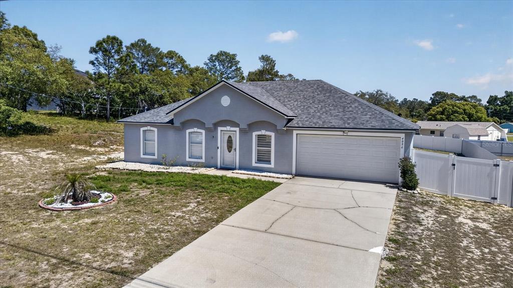 A gray, single-story house with a two-car garage and a concrete driveway — 4096 LANDOVER BOULEVARD, SPRING HILL, FL