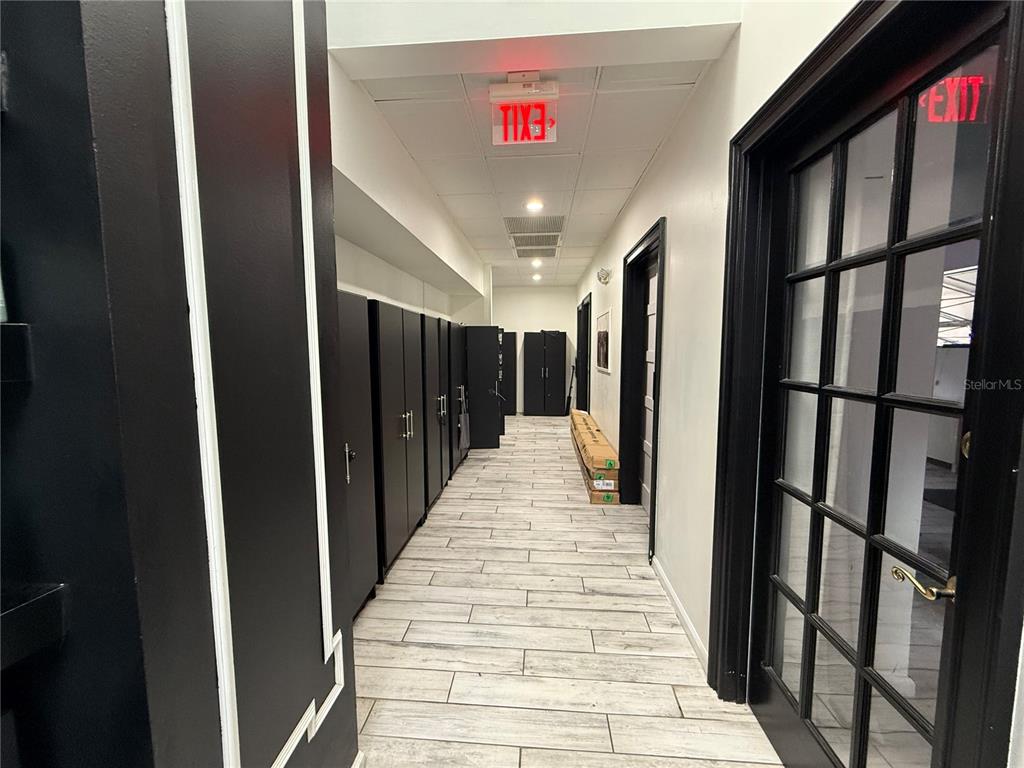 A hallway features light wood-look flooring, black storage cabinets, and a black-framed glass door — 1235 N ORANGE AVENUE, ORLANDO, FL